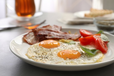 Photo of Tasty breakfast with fried eggs on grey table, closeup
