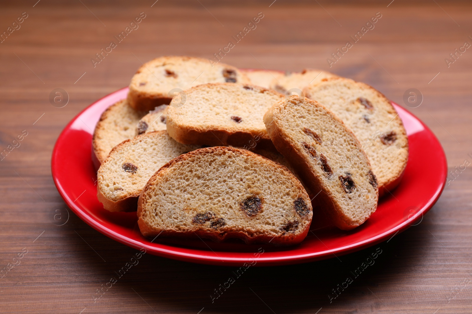 Photo of Plate of sweet hard chuck crackers with raisins on wooden table