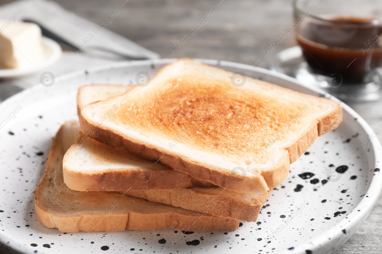 Photo of Plate with toasted bread on table, closeup