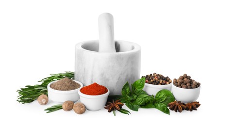 Mortar with pestle and different spices on white background