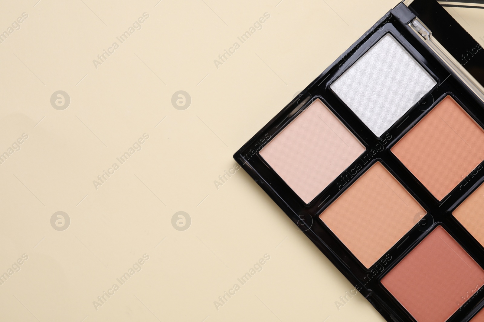Photo of Colorful contouring palette on beige background, top view with space for text. Professional cosmetic product