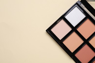 Colorful contouring palette on beige background, top view with space for text. Professional cosmetic product