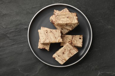 Photo of Tasty chocolate halva on black table, top view