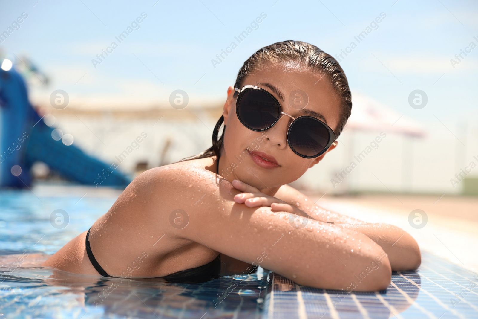 Photo of Young woman in outdoor swimming pool. Summer vacation