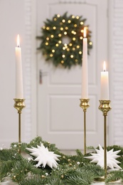 Christmas composition with burning candles on table in room