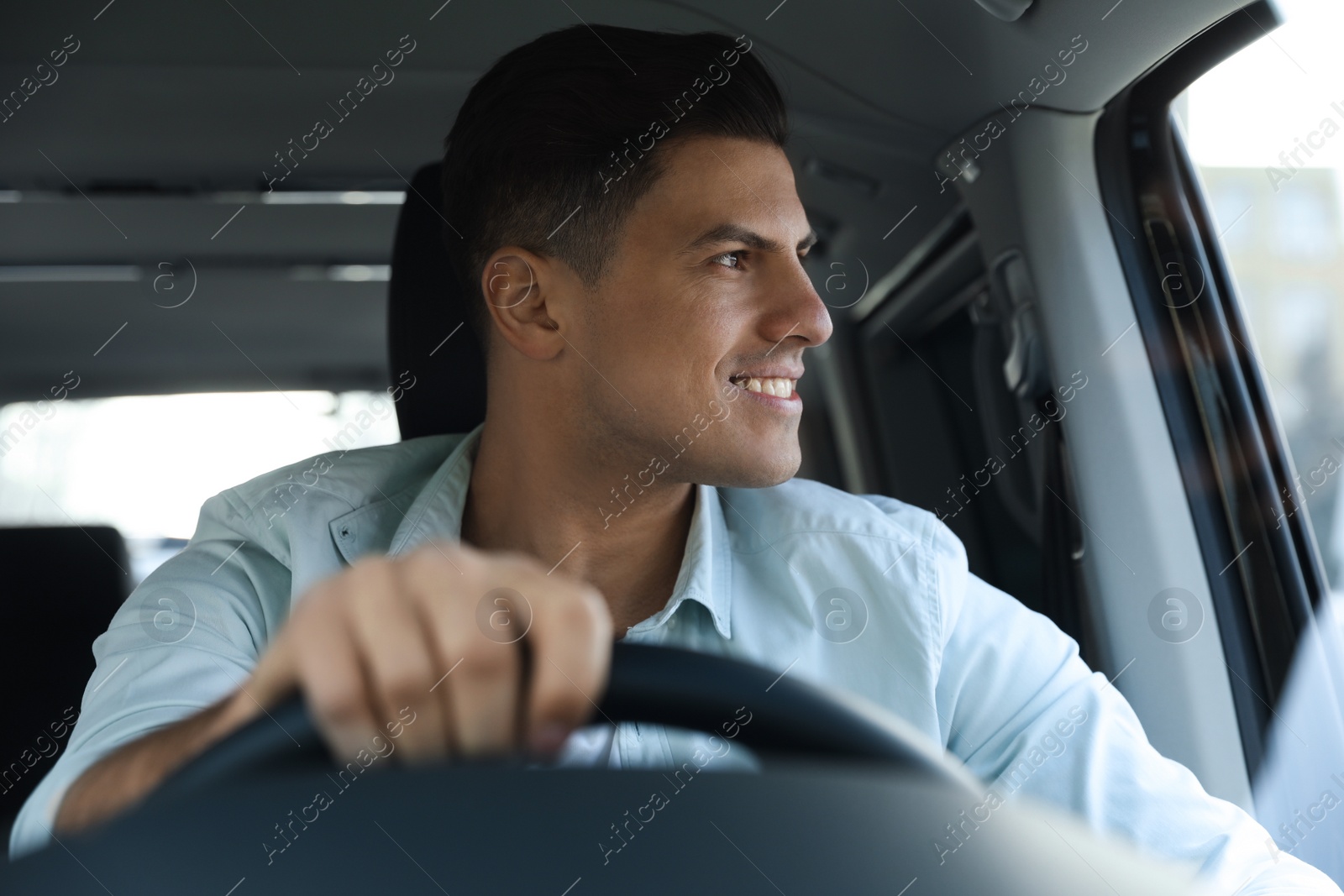 Photo of Handsome man driving his new modern car