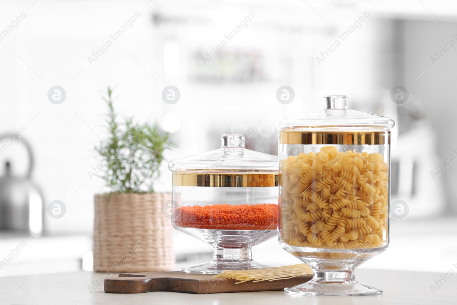 Photo of Jars with foodstuff on wooden table in modern kitchen