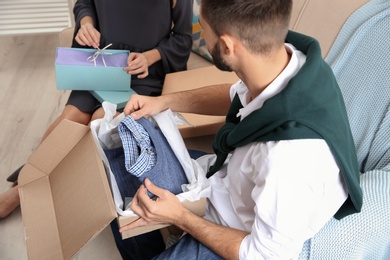 Young couple opening parcels in living room, closeup