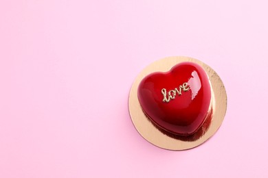 Photo of St. Valentine's Day. Delicious heart shaped cake on light pink background, top view. Space for text