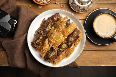 Delicious sweet baklava and aromatic coffee on wooden table, flat lay