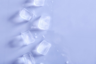 Photo of Ice cubes on color background, top view. Space for text