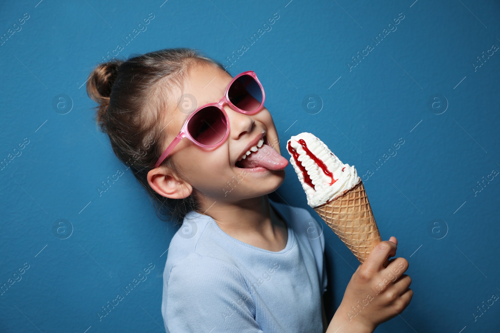 Photo of Adorable little girl with delicious ice cream against color background