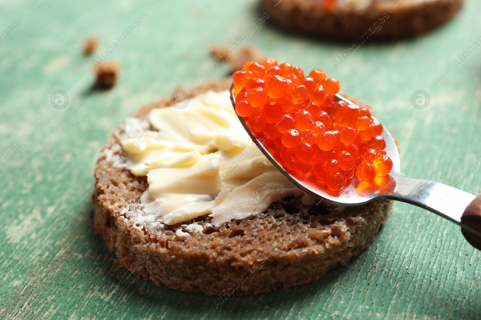 Photo of Delicious sandwich with red caviar on table, closeup