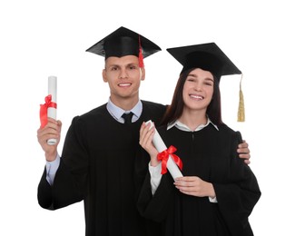 Photo of Happy students in academic dresses with diplomas on white background