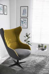 Photo of Comfortable armchair near white wall in light room