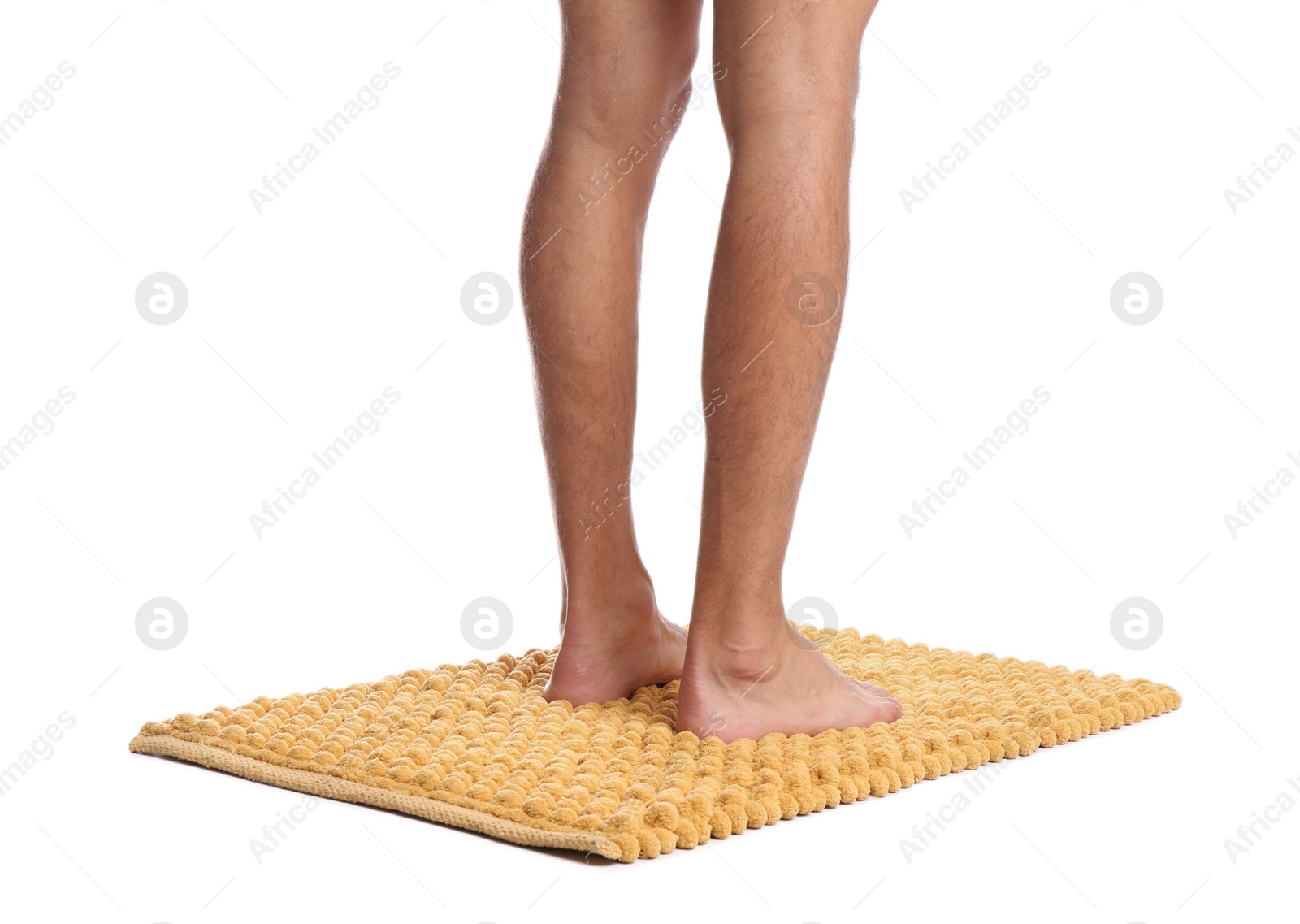 Photo of Man standing on soft yellow bath mat against white background, closeup