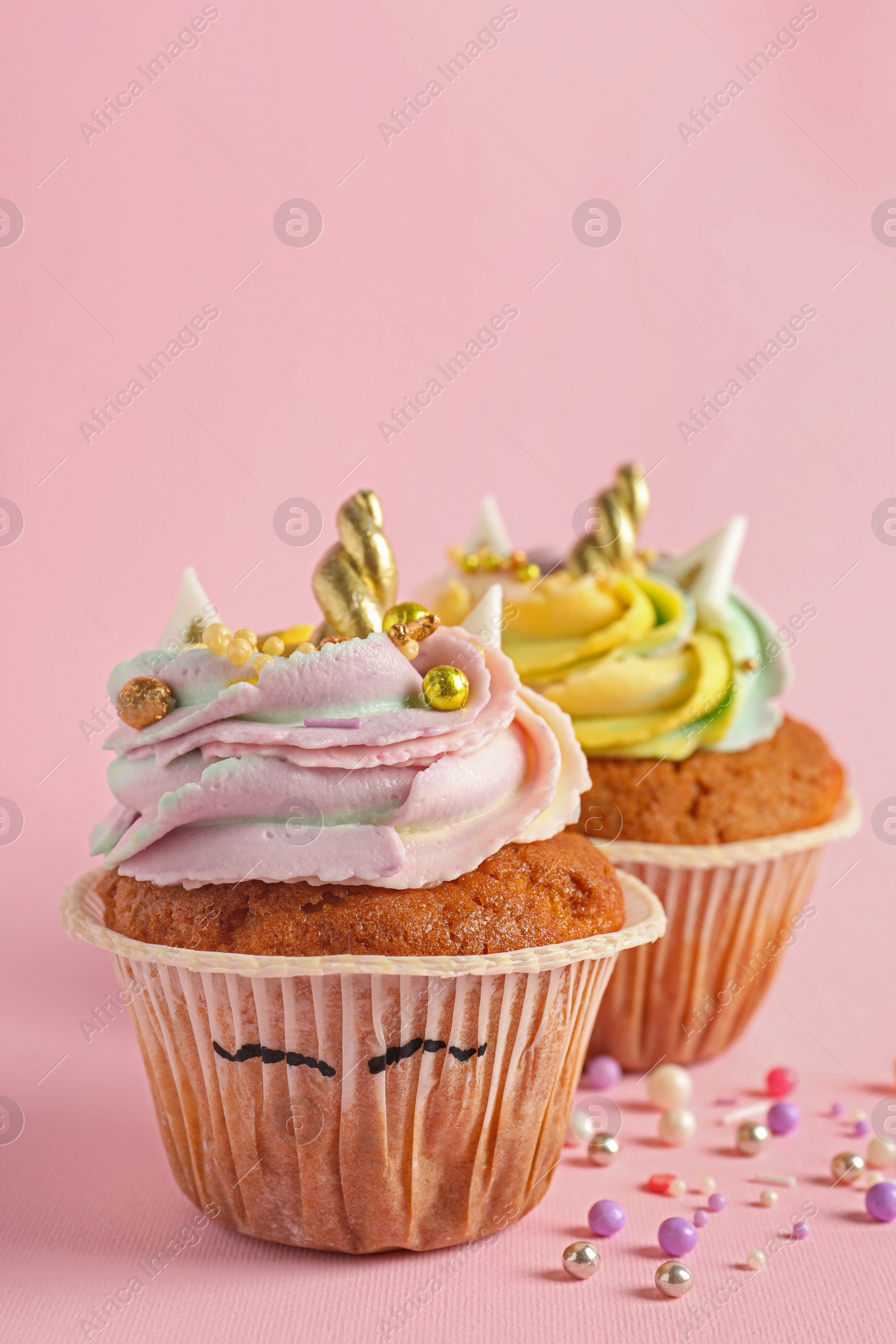 Photo of Cute sweet unicorn cupcakes on pink background