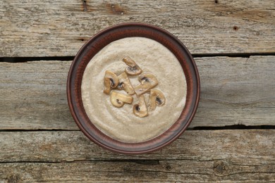 Delicious mushroom cream soup on wooden table, top view