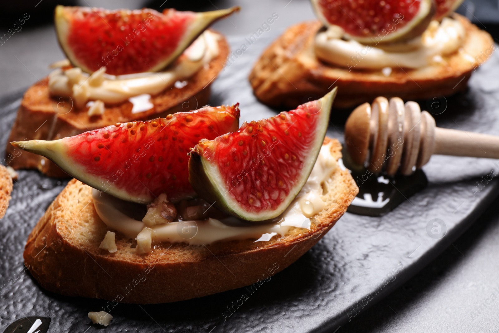 Photo of Bruschettas with ripe figs and cream cheese served on table, closeup