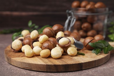 Photo of Tasty organic Macadamia nuts on brown table