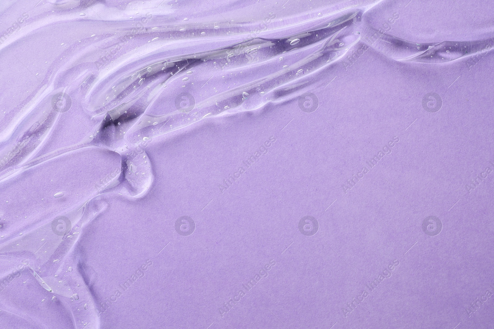 Photo of Clear cosmetic gel on violet background, top view. Space for text