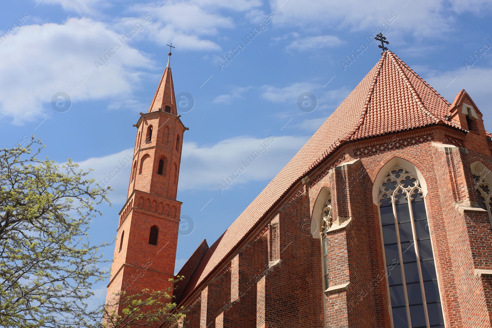 Photo of Brick Christian church against cloudy sky, low angle view