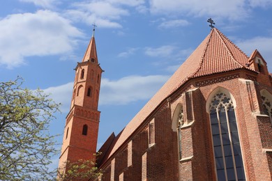 Brick Christian church against cloudy sky, low angle view