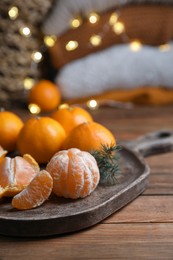 Photo of Tray with delicious ripe tangerines on wooden table