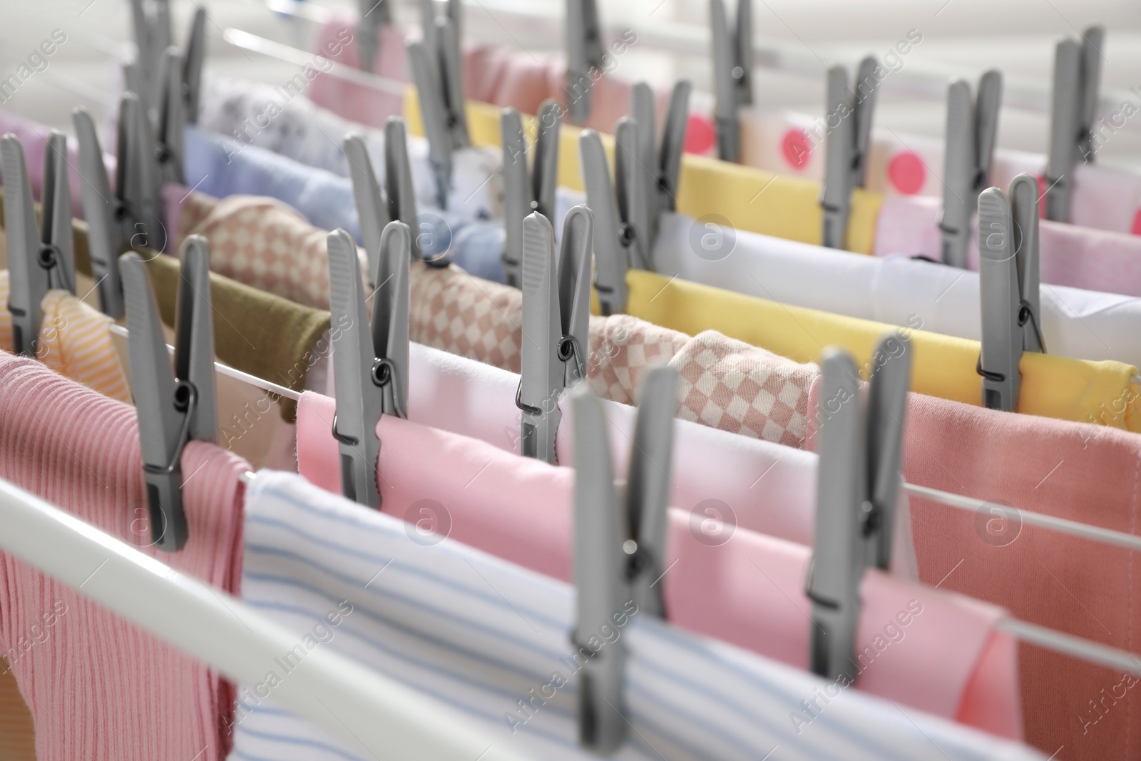 Photo of Clean laundry hanging on drying rack, closeup