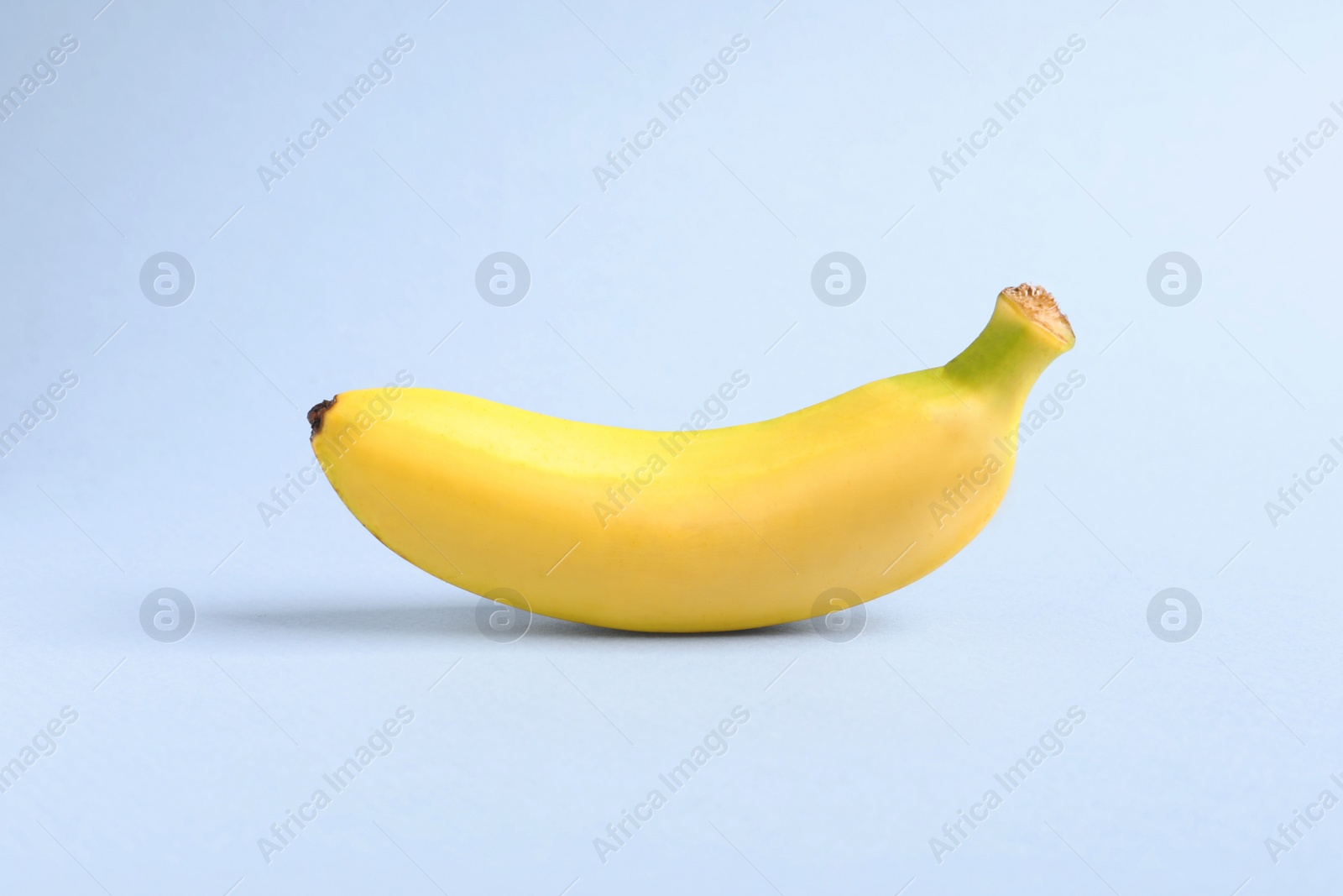 Photo of One sweet ripe baby banana on light background