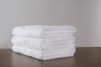 Photo of Stack of clean bath towels on dark grey table