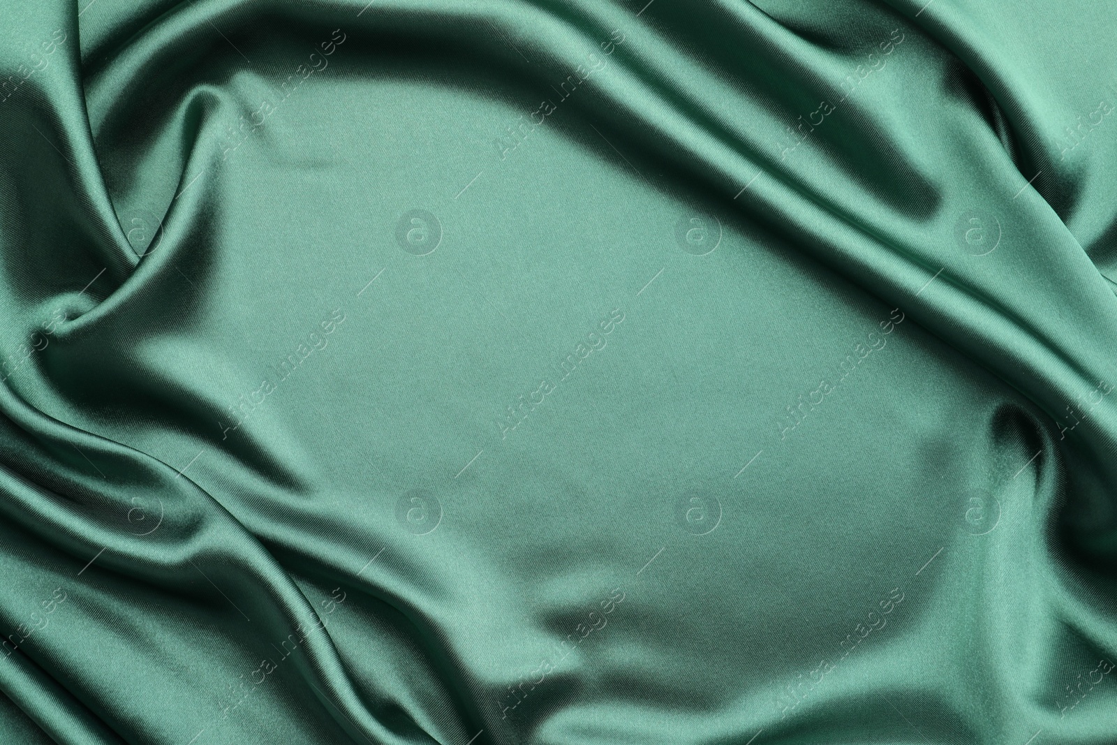 Photo of Crumpled green silk fabric as background, top view