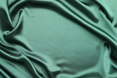 Crumpled green silk fabric as background, top view