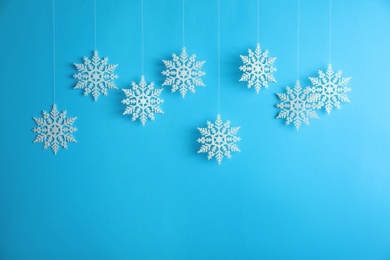 Beautiful decorative snowflakes hanging on light blue background