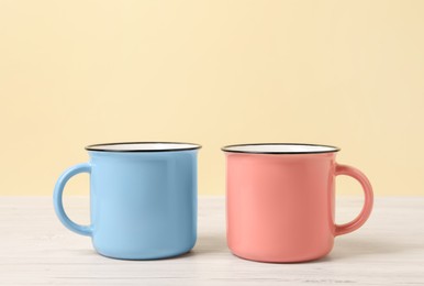 Photo of Blue and pink mugs on white wooden table. Gender equality