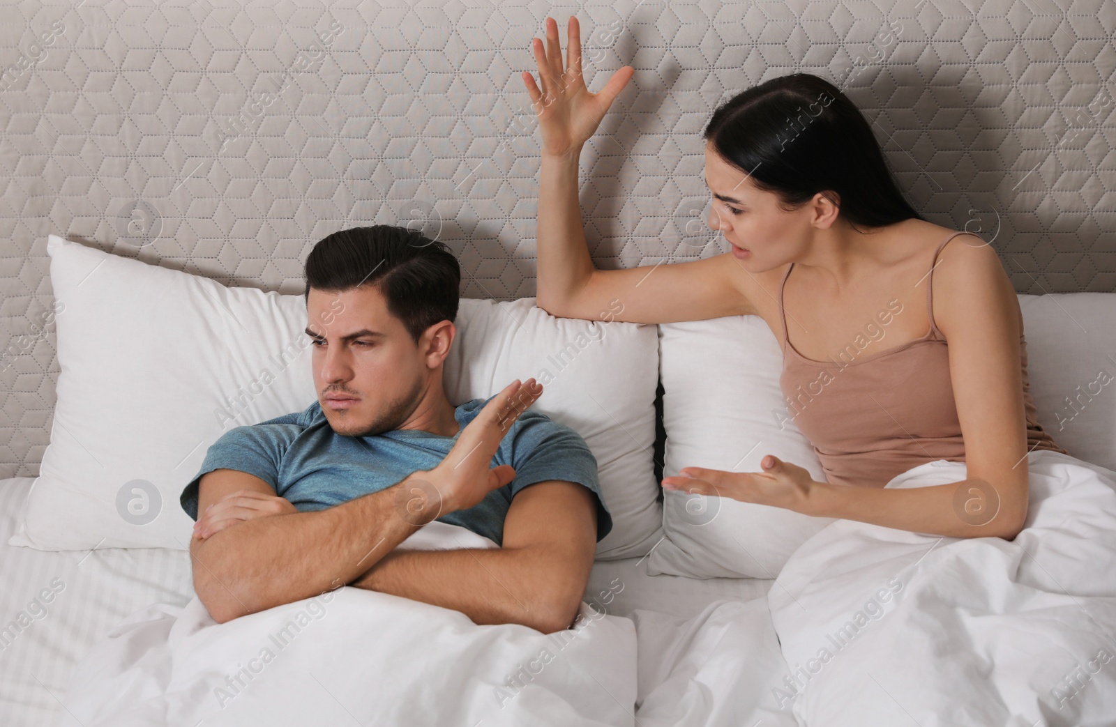 Photo of Couple quarreling in bed at home. Relationship problems