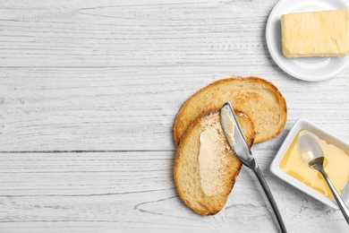 Photo of Toasted bread with butter on wooden background, top view