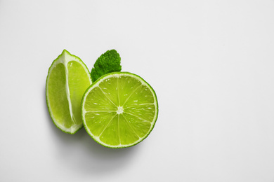 Photo of Cut fresh juicy lime and mint on white background, top view