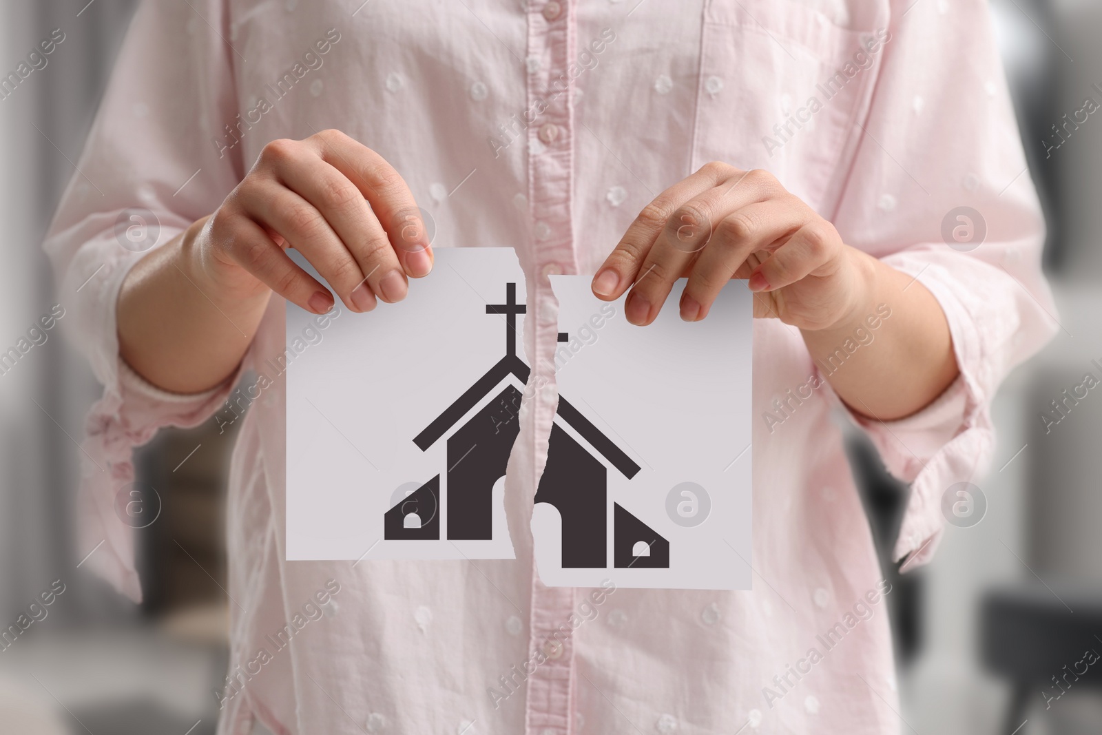 Image of Atheism as religious position. Woman ripping paper with illustration of church indoors, closeup