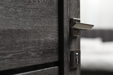 Photo of Open wooden door with metal handle, closeup