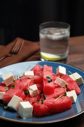 Photo of Delicious salad with watermelon and cheese on wooden table, closeup