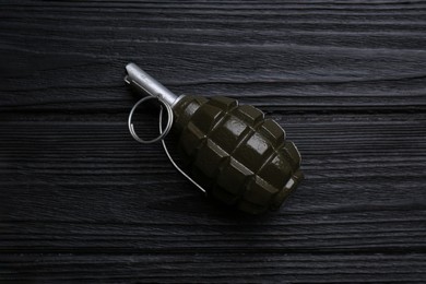 Photo of Hand grenade on black wooden table, top view