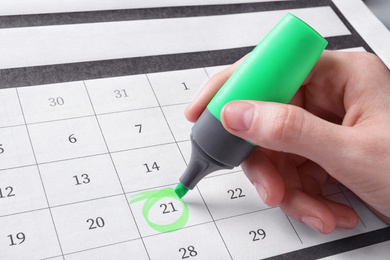 Photo of Woman marking date in calendar with felt pen, closeup