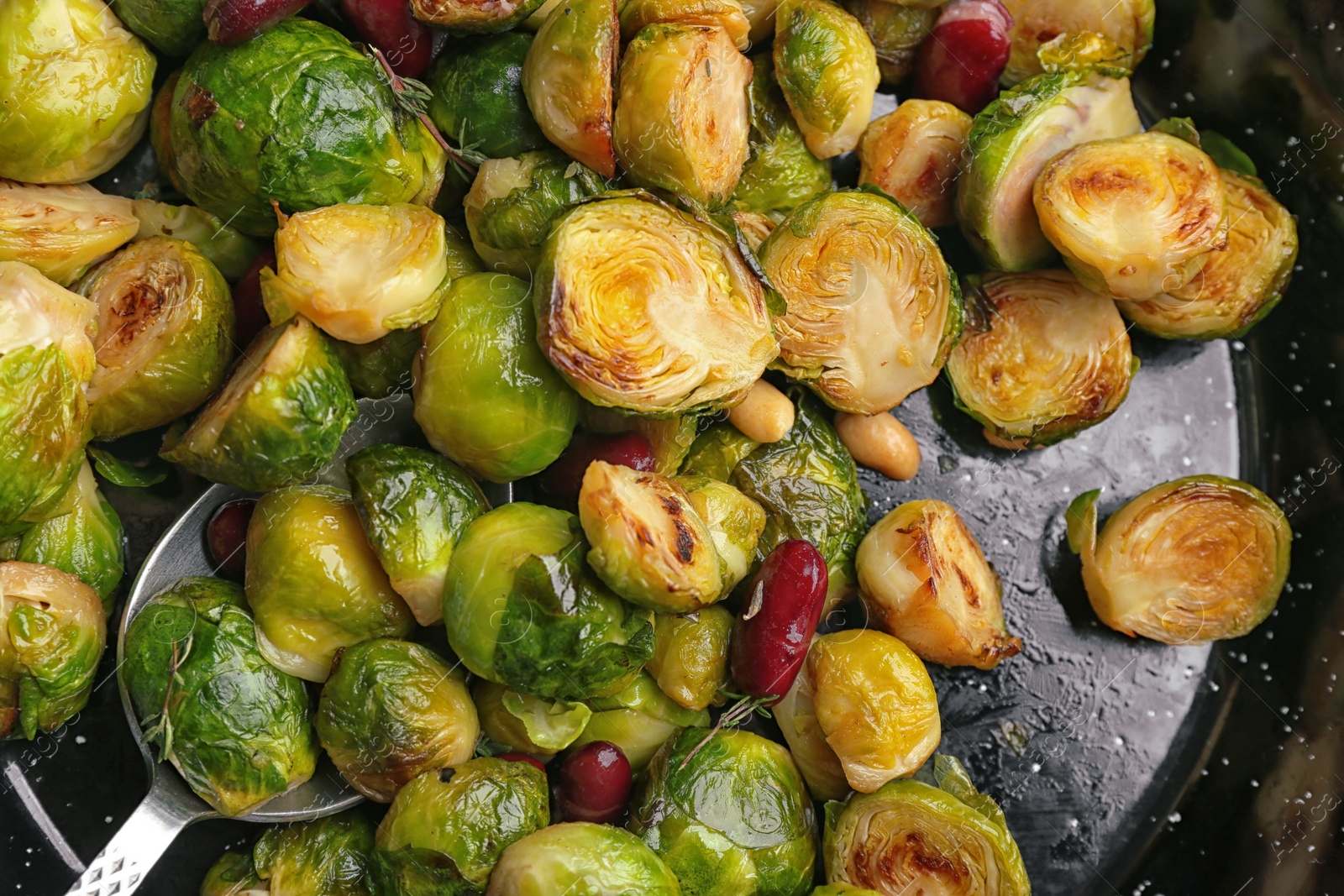 Photo of Delicious roasted brussels sprouts with red beans and peanuts in frying pan, closeup