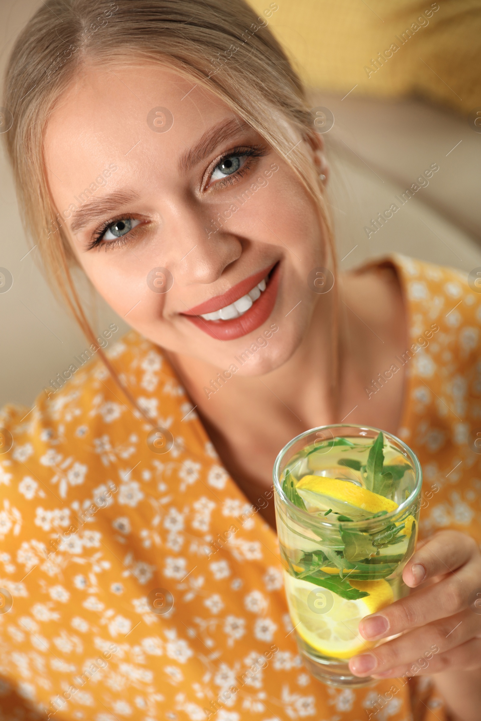 Photo of Young woman with glass of lemonade at home. Refreshing drink