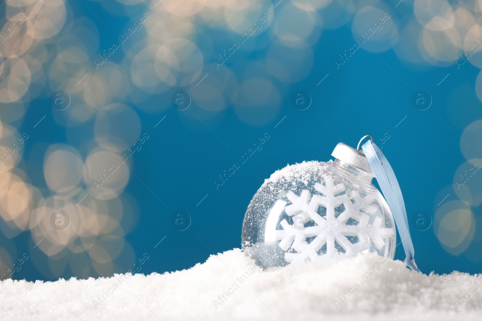 Photo of Decorative snow globe with snowflake against blurred festive lights, closeup. Space for text