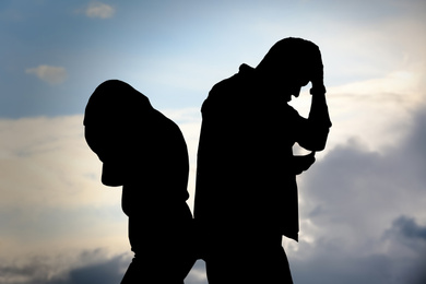 Image of Silhouettes of arguing couple against cloudy sky. Relationship problems