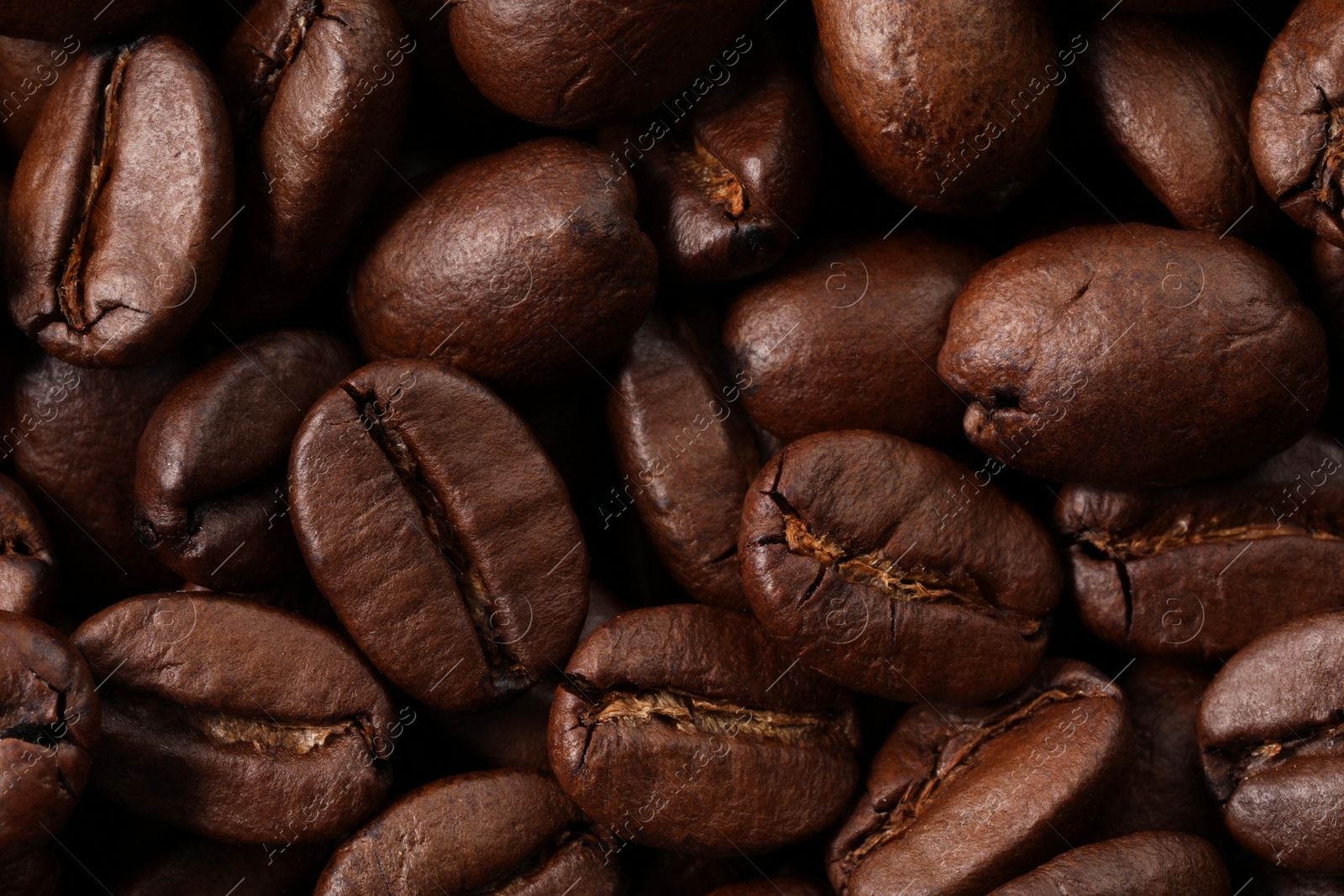 Photo of Aromatic roasted coffee beans as background, top view