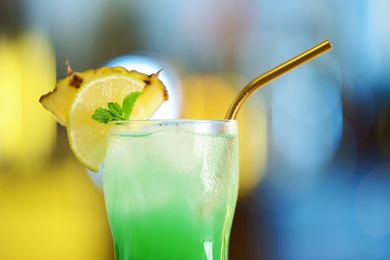 Photo of Fresh alcoholic cocktail with pineapple and lemon on blurred background, closeup
