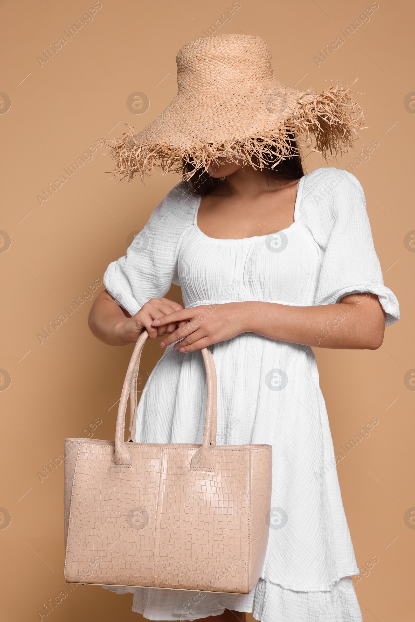 Photo of Young woman with stylish bag on beige background